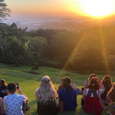 a group of people sitting at sunset