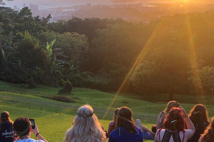 a group of people sitting at sunset