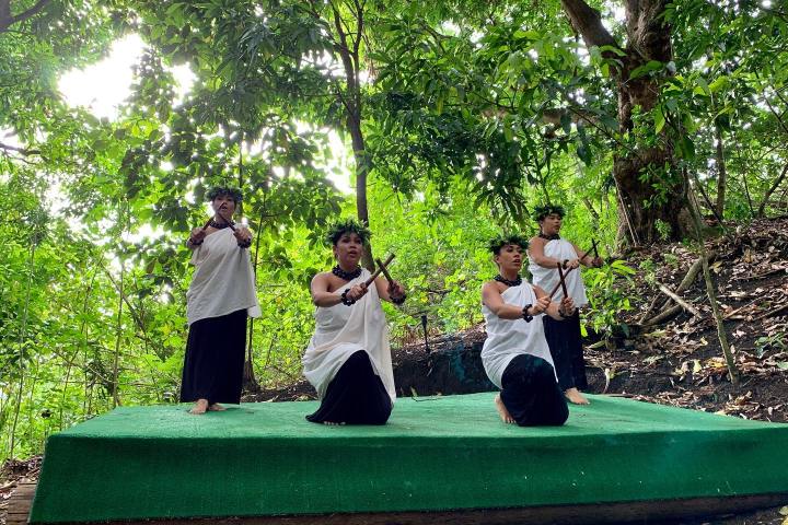 a group of people sitting on a bench in a park